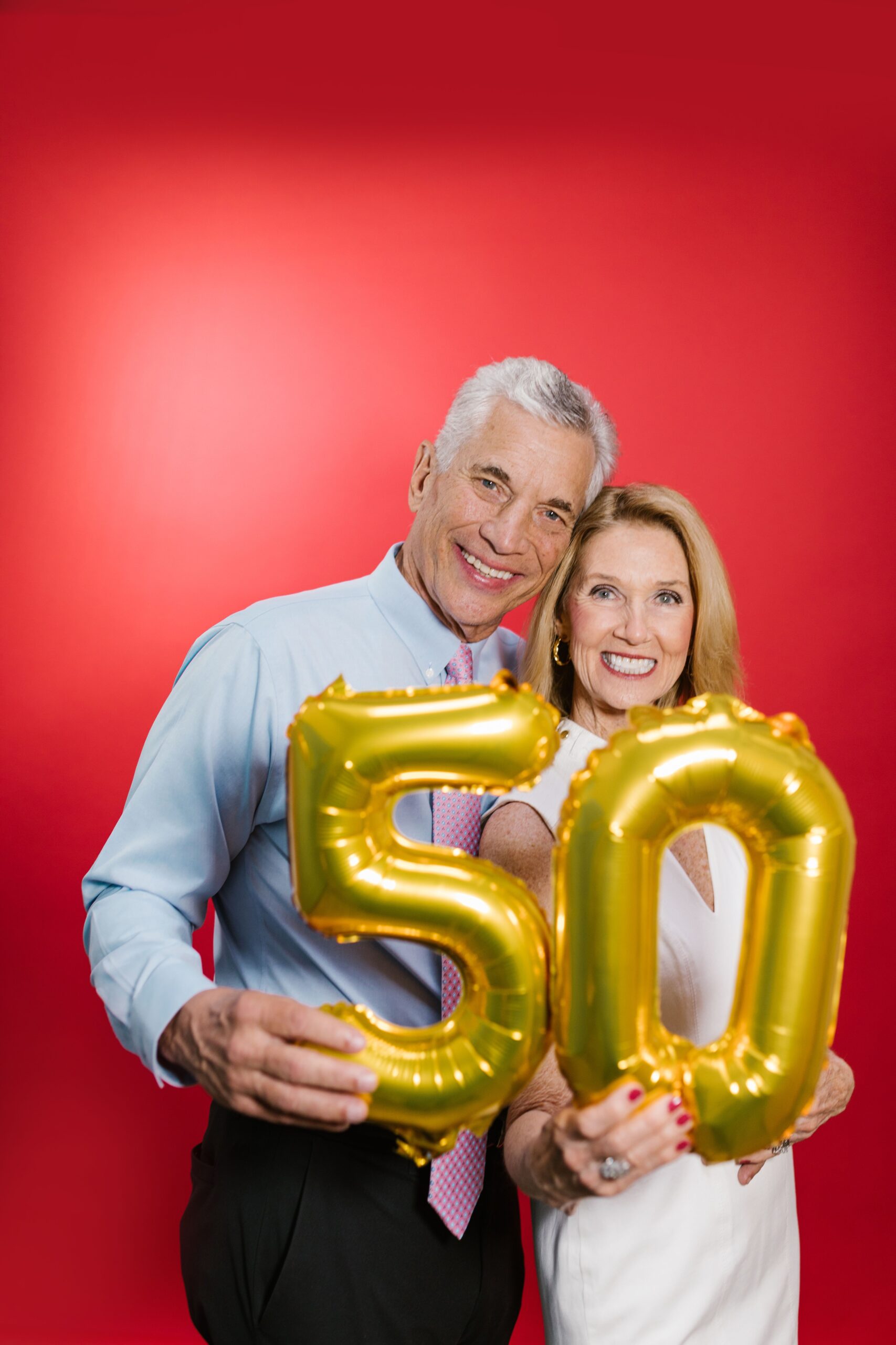 Paar mit goldenen 50-Ballons zum Thema Gewohnheiten ab 50
